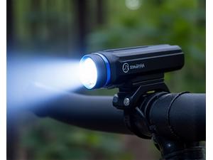 Powerful mountain bike headlight illuminating a dark, leafy trail.